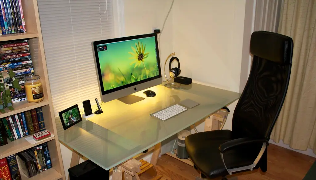 A wireless mouse next to a laptop with its USB receiver plugged in