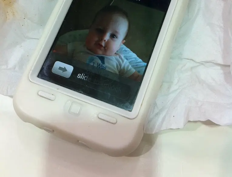 A hand holding an iPhone showing the Control Center interface
