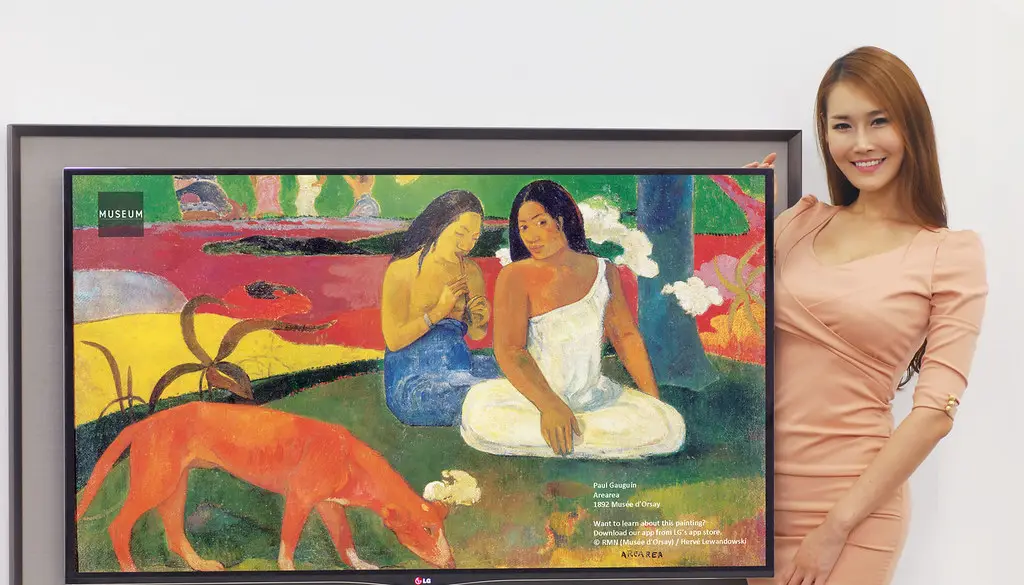 An OLED television displaying a vivid, colorful scene with deep blacks in a dark room