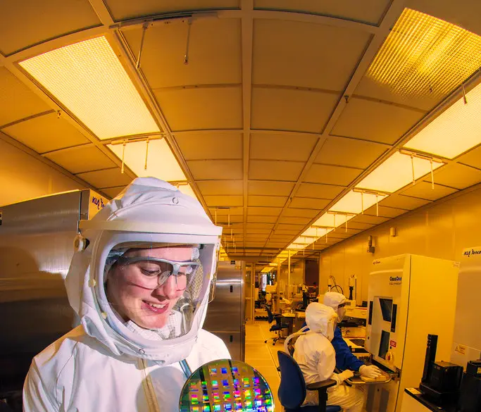A silicon wafer covered in semiconductor dies inside a fabrication facility
