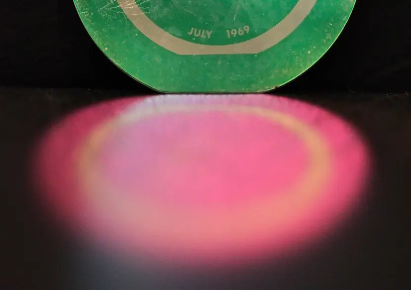 A semiconductor wafer with a grid of chip dies reflecting colored light